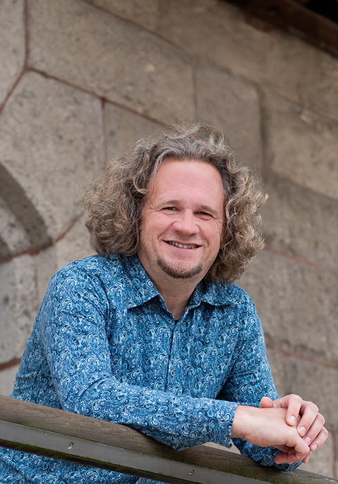 Portrait von Detlef Henke, lächelnd im Freien aufgenommen